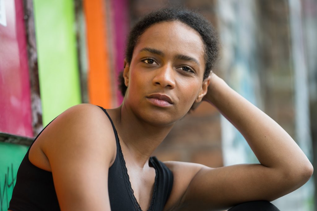 Portraitfotografie Berlin – natürliches Portrait einer jungen Frau vor buntem Graffiti