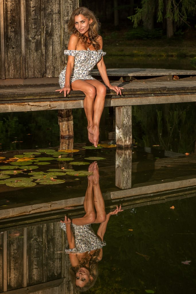 Outdoorportrait Frau im weißen Kleid auf Holzsteg mit Wasserreflexion, Portraitfotograf München