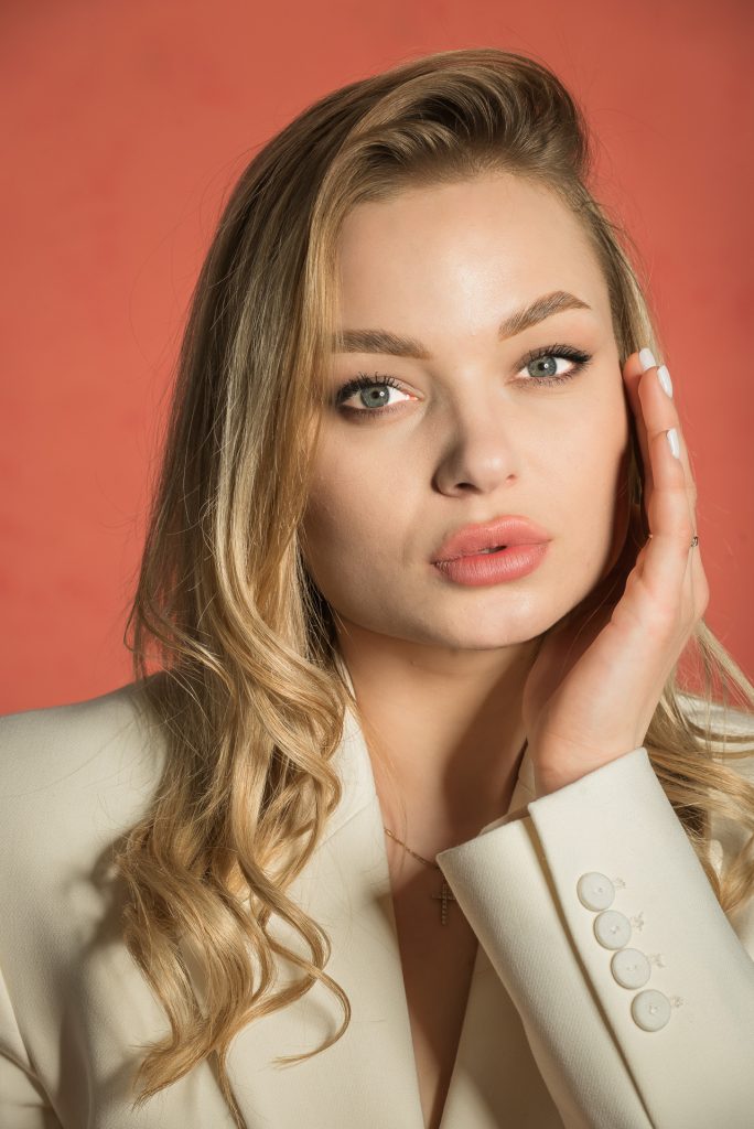 Studioportrait Frau mit blonden Haaren vor rotem handgemaltem Hintergrund, Portraitfotograf München
